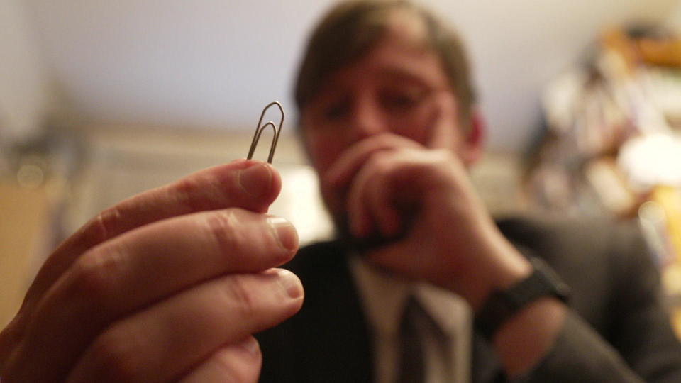 Pondering a paper clip.  / Credit: CBS News