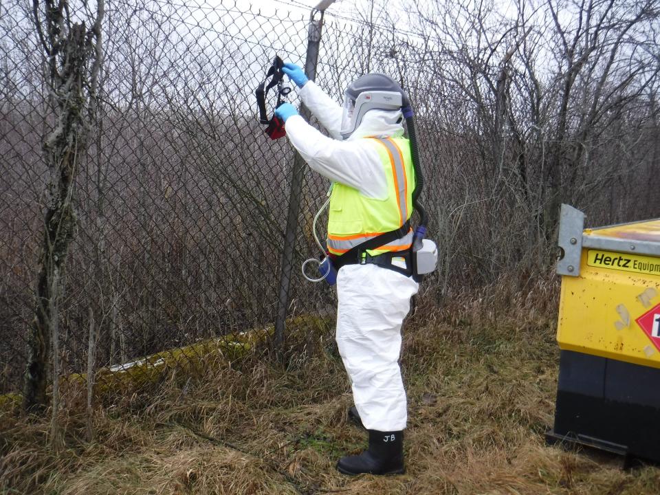 A U.S. Army Corps of Engineers staff member places a temporary air monitor on the perimeter fence of a former beryllium producing plant in Luckey, Ohio on Jan. 31, 2017. Radioactive soils from the project are proposed for shipment to the Wayne Disposal hazardous waste landfill near Belleville.