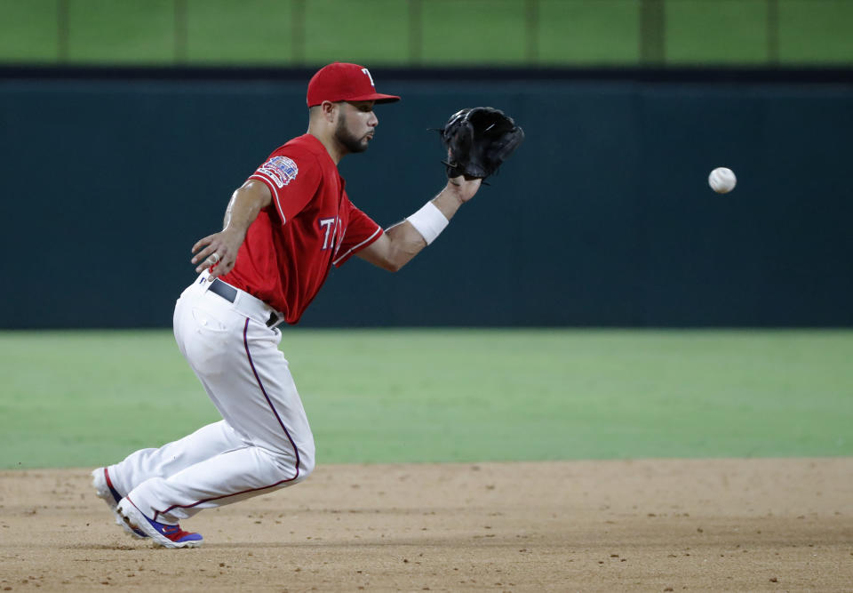 Texas Rangers third baseman Isiah Kiner-Falefa reaches to field a groundout by Los Angeles Angels' Wilfredo Tovar in the sixth inning of baseball game in Arlington, Texas, Monday, Aug. 19, 2019. (AP Photo/Tony Gutierrez)