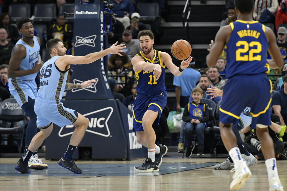 Golden State Warriors guard Klay Thompson (11) passes the ball ahead of Memphis Grizzlies guard John Konchar (46) in the first half of an NBA basketball game Friday, Feb. 2, 2024, in Memphis, Tenn. (AP Photo/Brandon Dill)