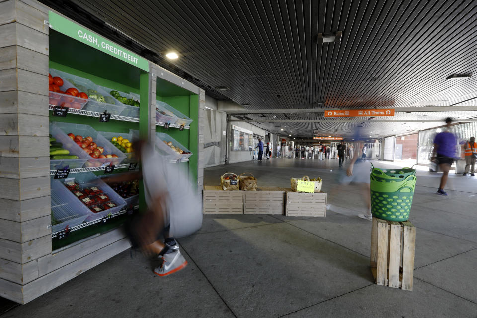 In this Tuesday, Aug. 20, 2019 photo, people pass by the Fresh MARTA Market in the West End transit station in Atlanta. The Metropolitan Atlanta Rapid Transit Authority and the Atlanta nonprofit Community Farmers Markets partner to run the stands, which sell food from some Atlanta urban farms. (AP Photo/Andrea Smith)