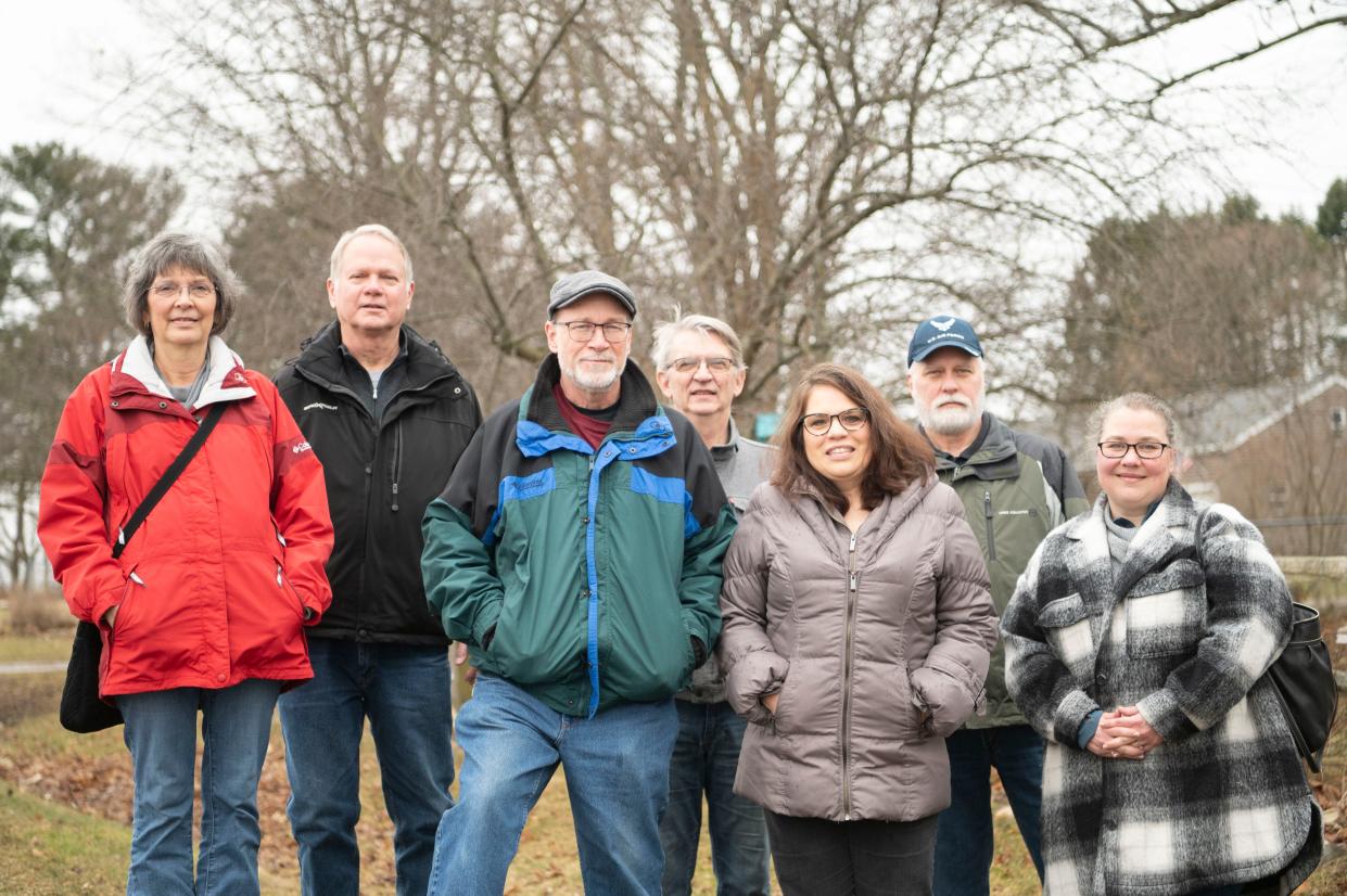 Marshall Township residents (L-R) Diane Kowalske, Glenn Kowalske, Fred Chapman, Dale Borders, Joan Chapman, Mick Woods and Marshall resident Laura Bartlett stand in front of homes along C Drive North across the street from the Megasite on Thursday, Feb. 16, 2023.