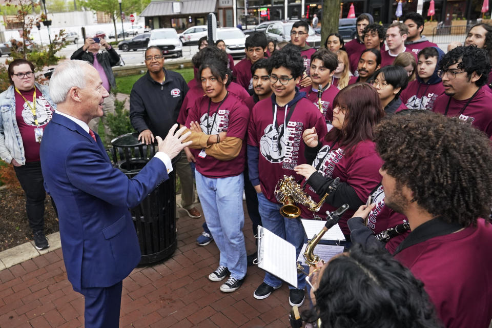 Former Arkansas Gov. Asa Hutchinson talks with members of the Springdale High School band before formally announces his Republican campaign for president, Wednesday, April 26, 2023, in Bentonville, Ark. (AP Photo/Sue Ogrocki)