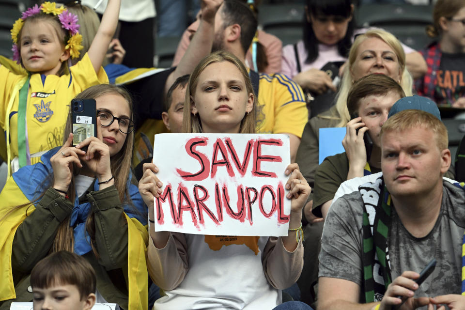 A spectator holds up a sign during the soccer match between Borussia Moenchengladbach and Ukraine's national soccer team at Borussia Park, Monchengladbach, Germany, Wednesday May 11, 2022. (Federico Gambarini/dpa via AP)