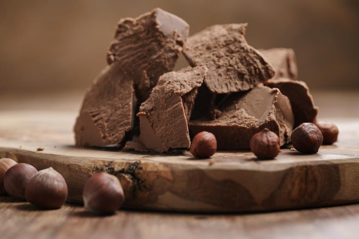 chunks of gianduja with hazelnuts on wood board, premium chocolate dessert