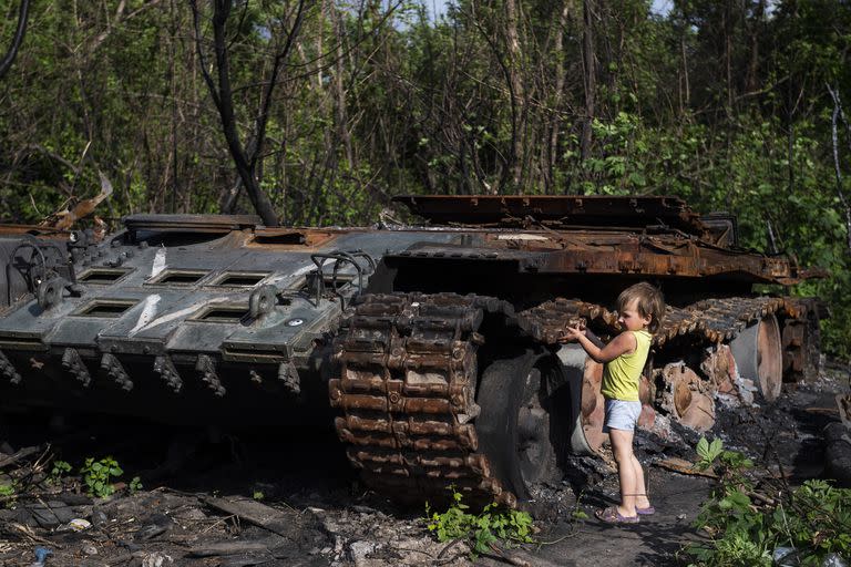 Niño juega junto a un tanque Ruso destruido en la ciudad de Kalynivka, en Ucrania.