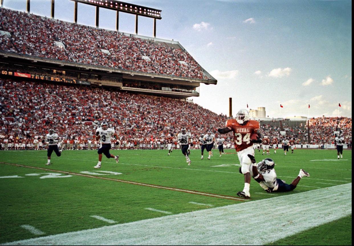 Texas running back Ricky Williams drags a Rice defender with him during a run in the Longhorns' 59-21 win in September 1998, a chunk of his 318-yard rushing performance that day. On Saturday, UT will honor him during the Texas-Kansas State game to mark the 25th anniversary of his Heisman Trophy season.