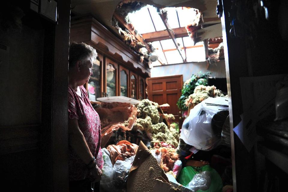 Faye Busby looks over her living room after a tornado ripped part of the roof off of her home in Graysville, Ala. on Tuesday, April 29, 2014. A strong line of tornado-producing storms made its way across the southeast Monday causing damage in the area. (AP Photo/AL.com, Tamika Moore)