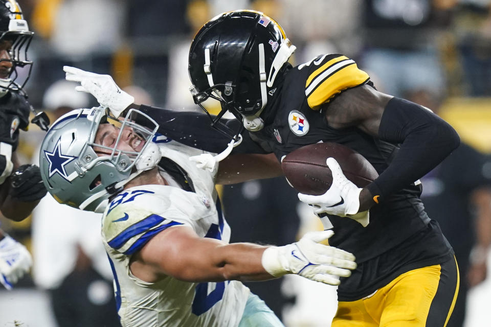 Pittsburgh Steelers cornerback Joey Porter Jr., right, puts a stiff arm on Dallas Cowboys tight end Jake Ferguson after making an interception during the second half of an NFL football game, early Monday, Oct. 7, 2024, in Pittsburgh. The Cowboys won 20-17. (AP Photo/Matt Freed)