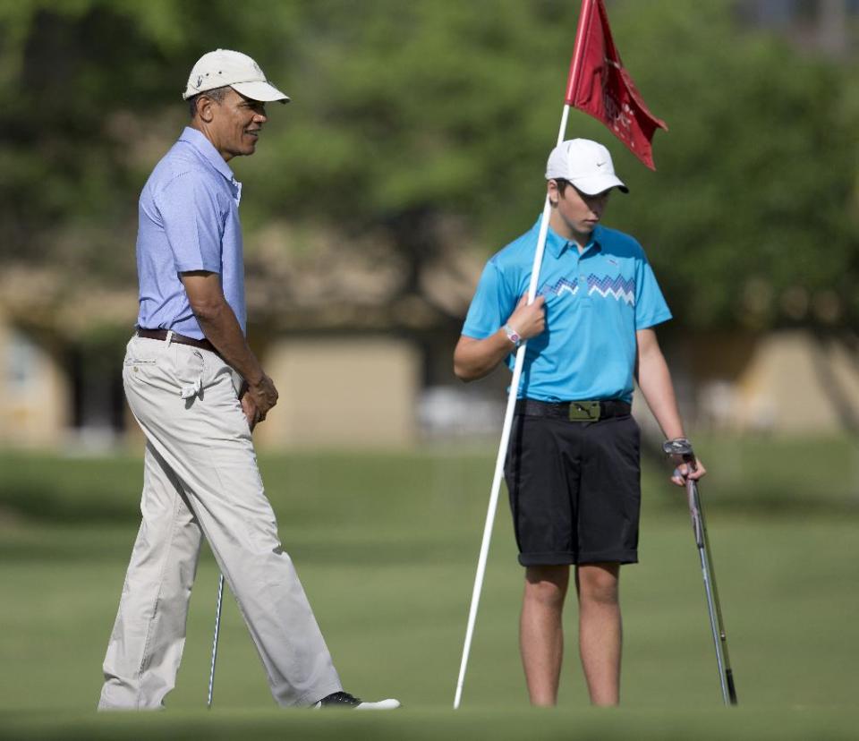 President Barack Obama, left, and Max Key, son of New Zealand Prime Minister John Key, golf on the second green at Kaneohe Klipper Golf Course on Marine Corps Base Hawaii, in Kaneohe Bay, Hawaii, Thursday, Jan. 2, 2014. The first family is in Hawaii for their annual holiday vacation. (AP Photo/Carolyn Kaster)