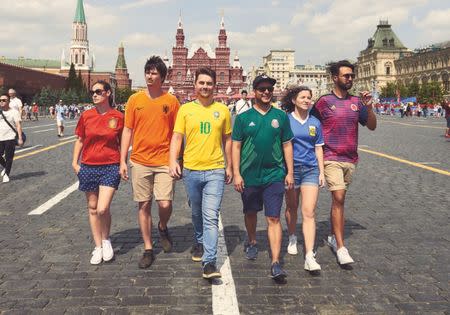 Gay rights activists, wearing soccer jerseys to form a rainbow flag, walk in Moscow's Red Square as they visit Russia during the World Cup, in this undated handout photo obtained by Reuters on July 10, 2018. Javier Tles/Handout via REUTERS