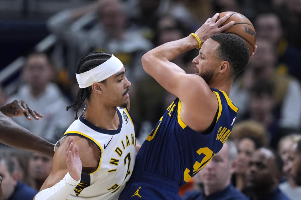 Golden State Warriors' Stephen Curry (30) is defended by Indiana Pacers' Andrew Nembhard (2) during the first half of an NBA basketball game Thursday, Feb. 8, 2024, in Indianapolis. (AP Photo/Darron Cummings)