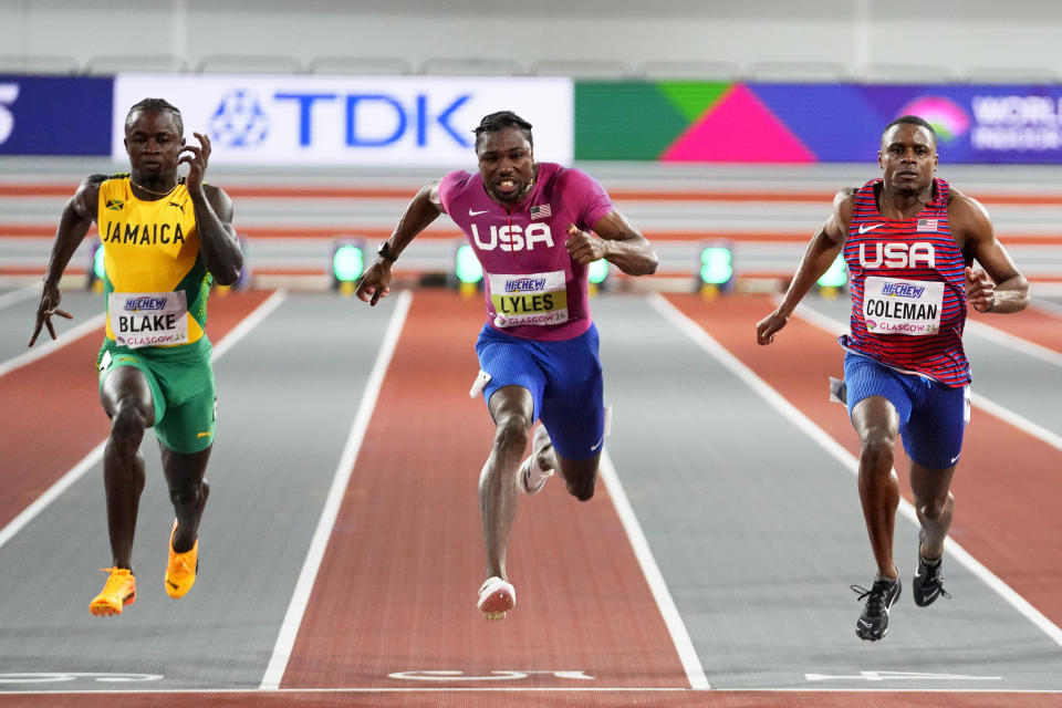 gold medalist Christian Coleman, of the United States, Silver medalist Noah Lyles, of the United States, and bronze medalist Ackeem Blake, of Jamaica, from right, cross the finish line in the men's 60 meters final during the World Athletics Indoor Championships at the Emirates Arena in Glasgow, Scotland, Friday, March 1, 2024. (AP Photo/Petr David Josek)