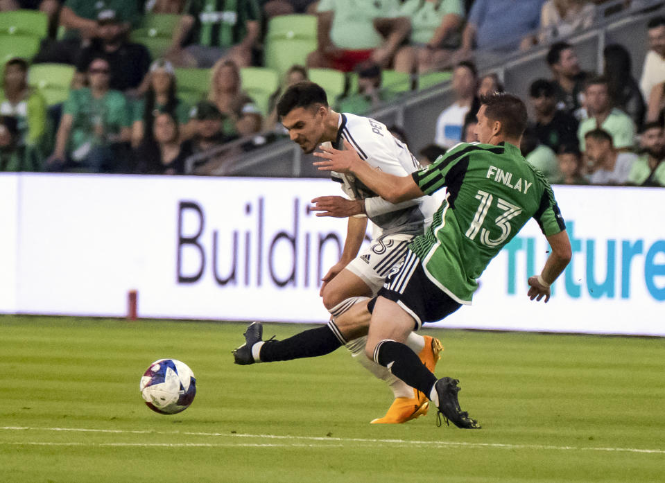 Toronto FC defender Raoul Petretta, left, and Austin FC midfielder Ethan Finley, right, vie for the ball during the first half of an MLS soccer game, Saturday, May 20, 2023, in Austin, Texas. (AP Photo/Michael Thomas)