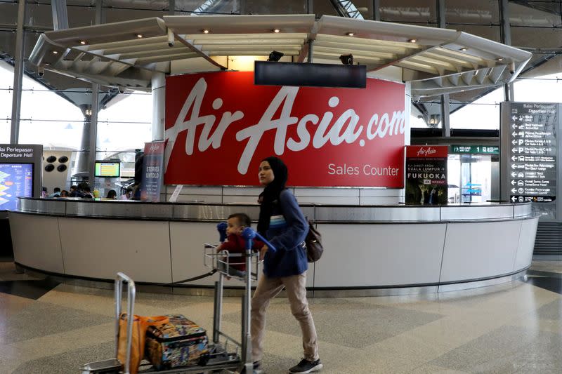 A woman walks past an AirAsia counter at Kuala Lumpur International Airport in Sepang
