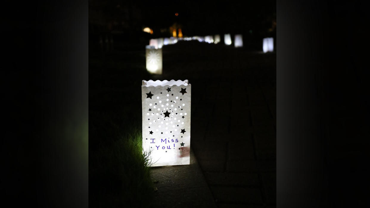 A luminary on the sidewalk reads: I miss you!