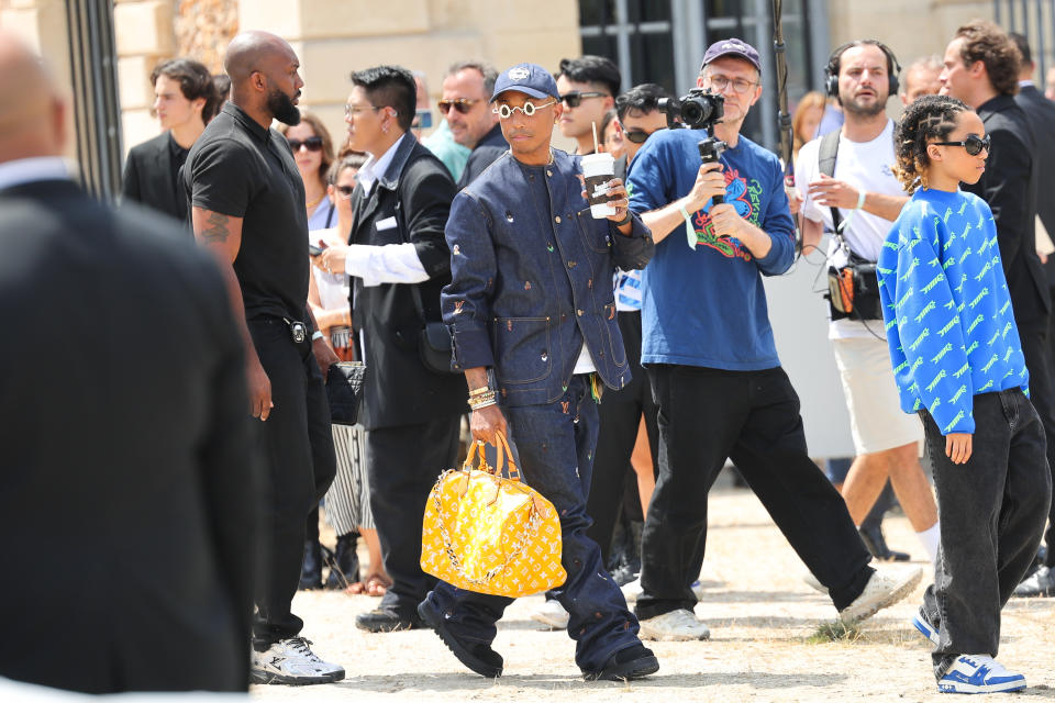 Pharrell Williams pairs Louis Vuitton’s Millionaire Speedy bag with a head-to-toe denim outfit.