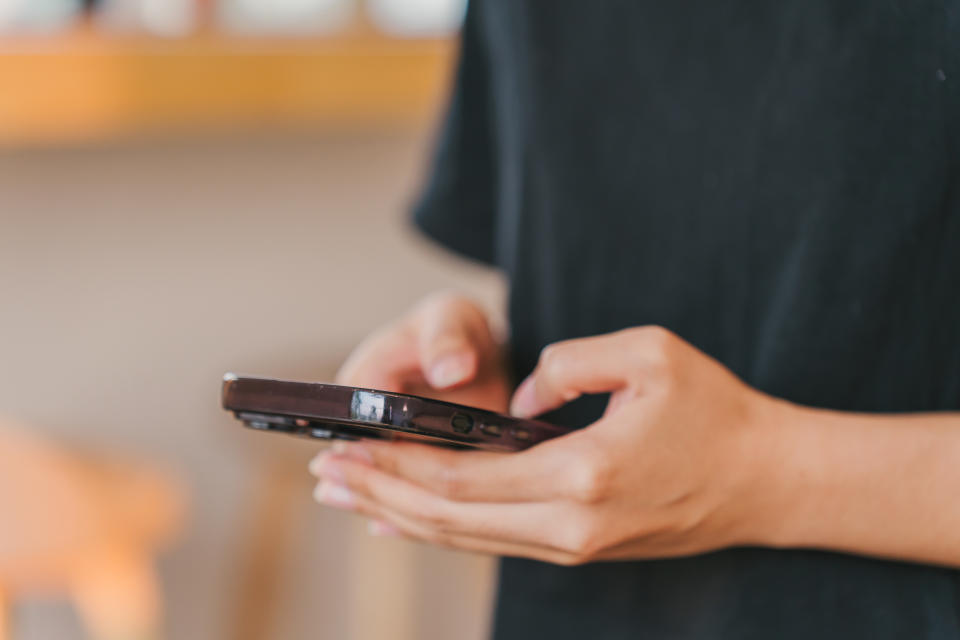 Person using a smartphone, focusing on their hands and the device