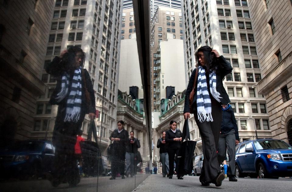 People walk to work on Liberty Street in the financial district of Manhattan, New York on May, 21, 2013.