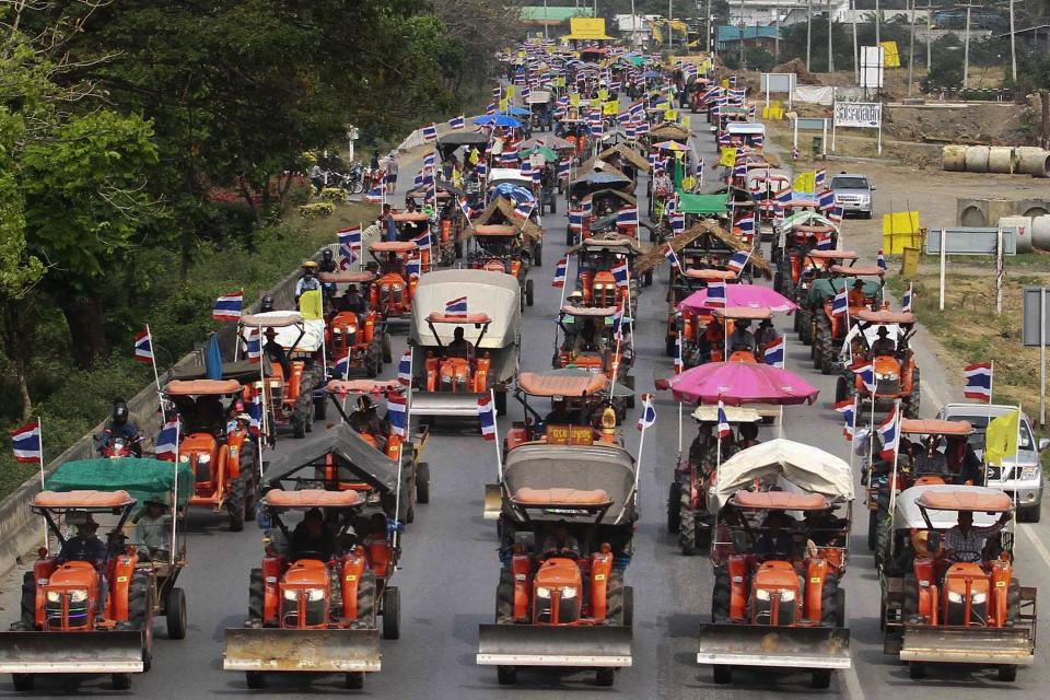 Farmers drive their tractors and other farming vehicles on a road in Ang Thong province, towards Bangkok, February 20, 2014. More than 1,000 farmers, many riding in farm trucks, are travelling in a convoy towards Bangkok from the rice-growing central plains and were due to reach the city overnight or on Friday. Chada Thaiseth, a former member of parliament, said he would lead farmers on Friday to Bangkok's Suvarnabhumi Airport, blockaded for eight days by royalist, anti-Thaksin "yellow shirts" in 2008. REUTERS/Stringer (THAILAND - Tags: POLITICS CIVIL UNREST AGRICULTURE) ATTENTION EDITORS - NO SALES. NO ARCHIVES. FOR EDITORIAL USE ONLY. NOT FOR SALE FOR MARKETING OR ADVERTISING CAMPAIGNS. THAILAND OUT. NO COMMERCIAL OR EDITORIAL SALES IN THAILAND