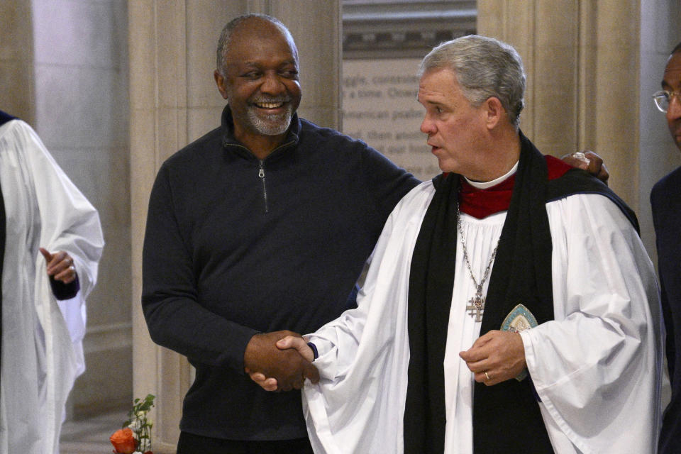 Artist Kerry James Marshall, left, shakes hands with Dean Hollerith, right, during an unveiling and dedication ceremony at the Washington National Cathedral for the new stained-glass windows with a theme of racial justice, Saturday, Sept. 23, 2023, in Washington. The new windows, titled “Now and Forever," are based on a design by Marshall. Marshall, who was born in Birmingham in 1955, invited anyone viewing the new windows, or other artworks inspired by social justice, “to imagine oneself as a subject and an author of a never-ending story is that is still yet to be told.” (AP Photo/Nick Wass)