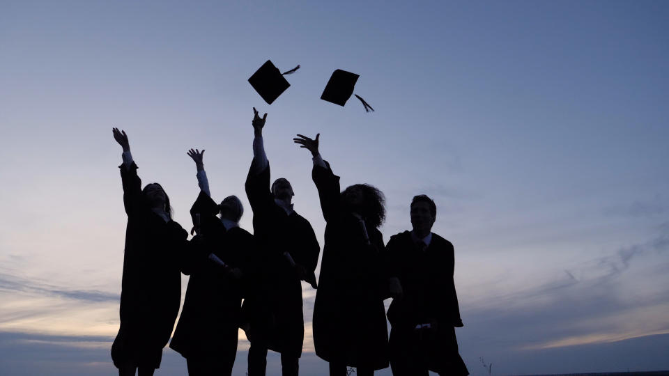 Wide shot. Slow motion. Silhouette of Graduating Students Throwing Caps In The Air. Professional shot in 4K resolution. 035. You can use it e.g. in your commercial video, medical, business, presentation, broadcast