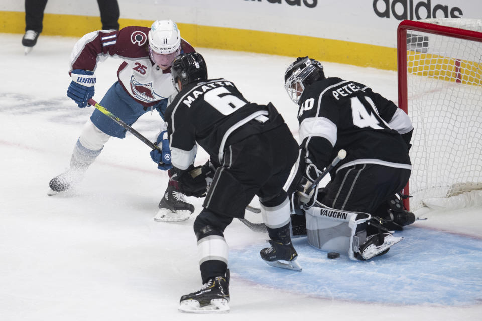 Los Angeles Kings goaltender Calvin Petersen, right, blocks a shot by Colorado Avalanche left wing Matt Calvert, left, during the first period of an NHL hockey game Tuesday, Jan. 19, 2021, in Los Angeles. (AP Photo/Kyusung Gong)