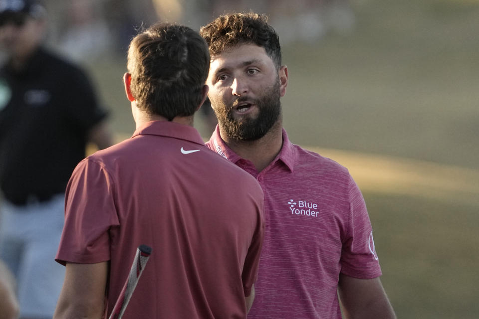 Jon Rahm, right, shakes hands with Davis Thompson after Rahm won the American Express golf tournament on the Pete Dye Stadium Course at PGA West Sunday, Jan. 22, 2023, in La Quinta, Calif. (AP Photo/Mark J. Terrill)