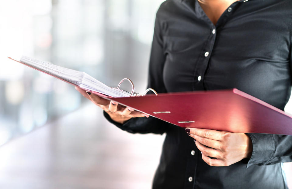 A person holding an open three-ringed binder