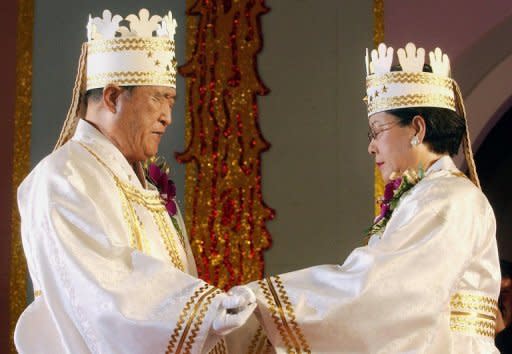 File photo taken in 2002 shows Unification Church founder Sun Myung Moon (L) and his wife Hak Ja Han during a mass wedding ceremony in Seoul. Moon's death robs his Unification Church of the glue that sustained its global following as a cohesive religious and financial force even as membership dwindled from its 1980s peak, analysts say