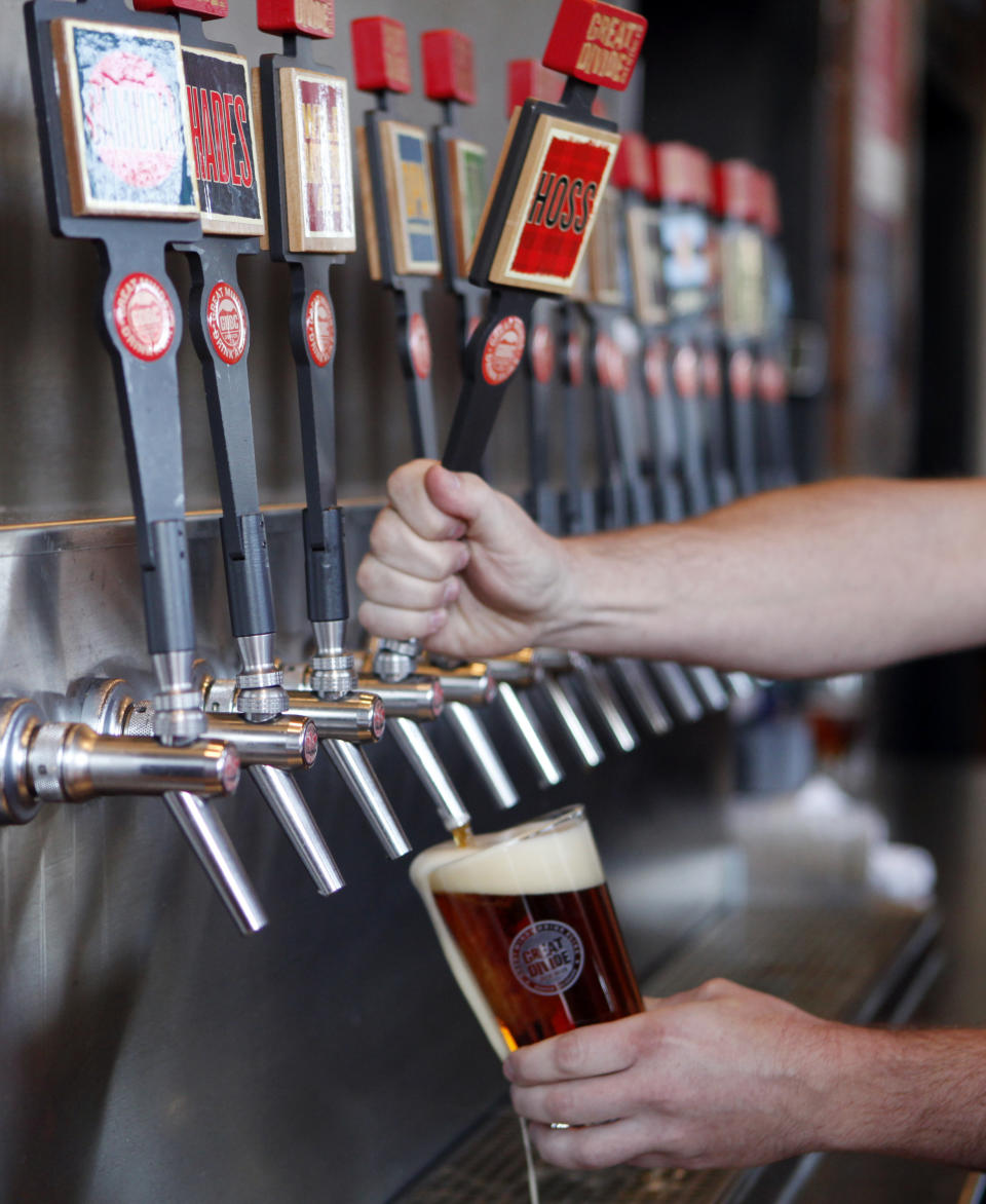 This photo taken on Dec. 7, 2012 shows a glass of beer being drawn from one of 16 taps at the Great Divide Brewery in Denver. A short walk from the 16th Street Mall: a sample of makers of beloved, homegrown Colorado craft beer. Wynkoop Brewing Co., co-founded by Gov. John Hickenlooper, and Great Divide Brewing Co. offer free tours of their downtown operations. (AP Photo/Ed Andrieski)