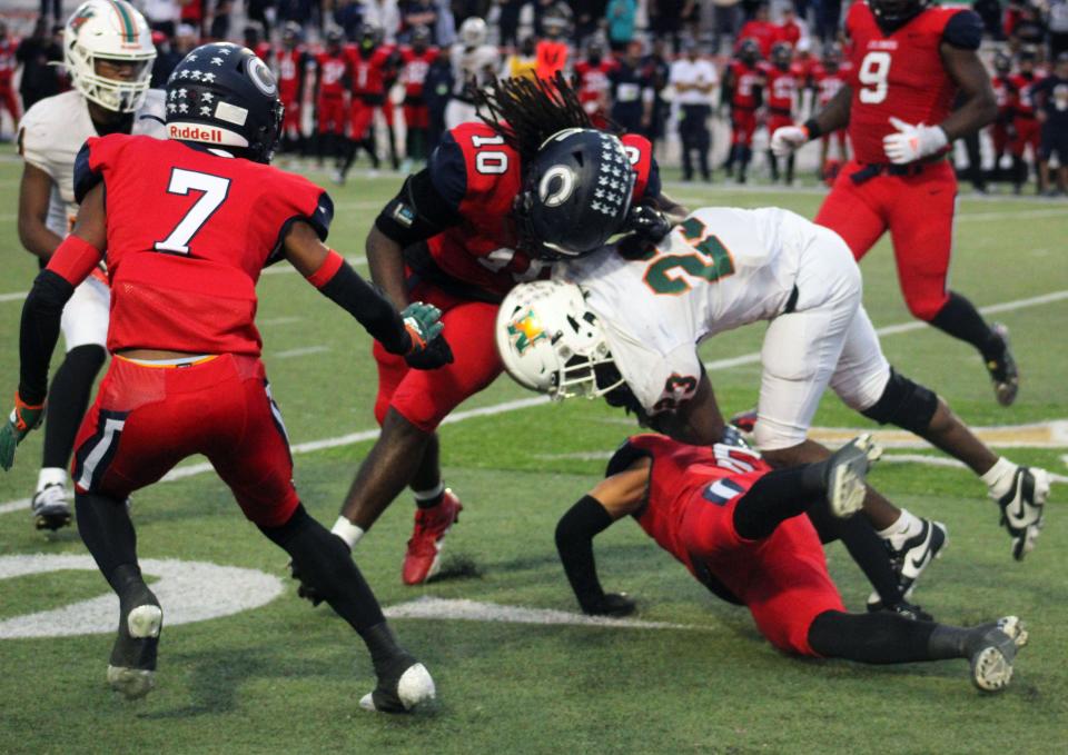 Miami Columbus linebacker Hector Chavez (10) and safety Jason Ibarra (5) combine to tackle Mandarin running back Deshard Wescott (23) during the FHSAA Class 4M high school football championship game on December 8, 2023. [Clayton Freeman/Florida Times-Union]