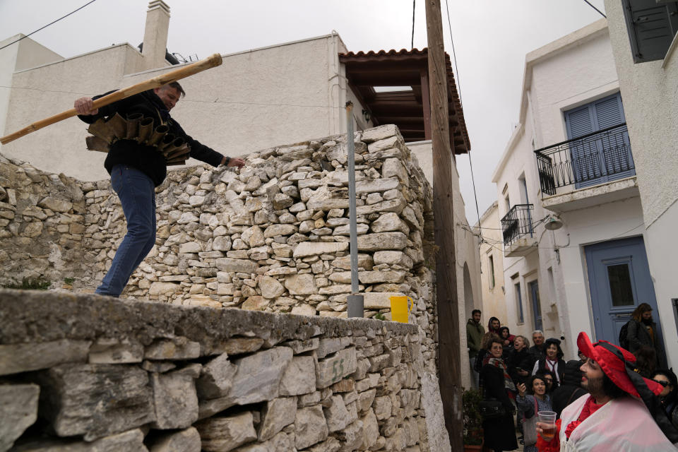 A bell ringer (Koudounatoi) dances during a traditional custom, in the village of Apeiranthos, on the Aegean Sea island of Naxos, Greece, on Sunday, Feb. 26, 2023. The first proper celebration of the Carnival after four years of COVID restrictions, has attracted throngs of revellers, Greek and foreign, with the young especially showing up in large numbers. (AP Photo/Thanassis Stavrakis)