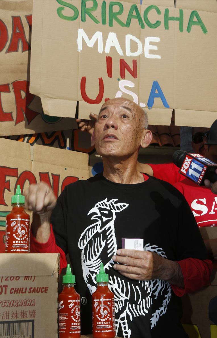 Sriracha hot sauce founder David Tran vows to stay in Irwindale, Calif., as he is joined by supporters protesting ahead of the city council meeting in Irwindale, Calif., Wednesday, April 23, 2014. The Irwindale City Council has declared that the factory that produces the popular Sriracha hot sauce is a public nuisance. (AP Photo/Damian Dovarganes)