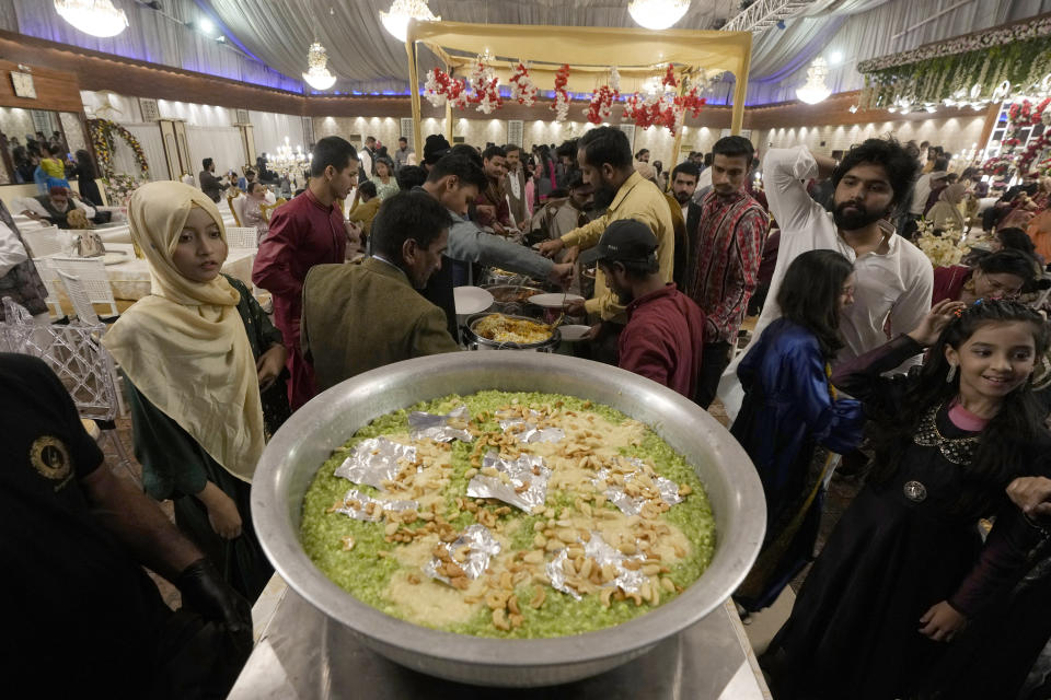 Guests take meal during a wedding ceremony at Radiance banqueting hall, in Karachi, Pakistan, Saturday, Jan. 27, 2024. There's a scrum of people trying to get photos with the married couple at the Radiance banqueting hall in a middle-class Karachi neighborhood. (AP Photo/Fareed Khan)