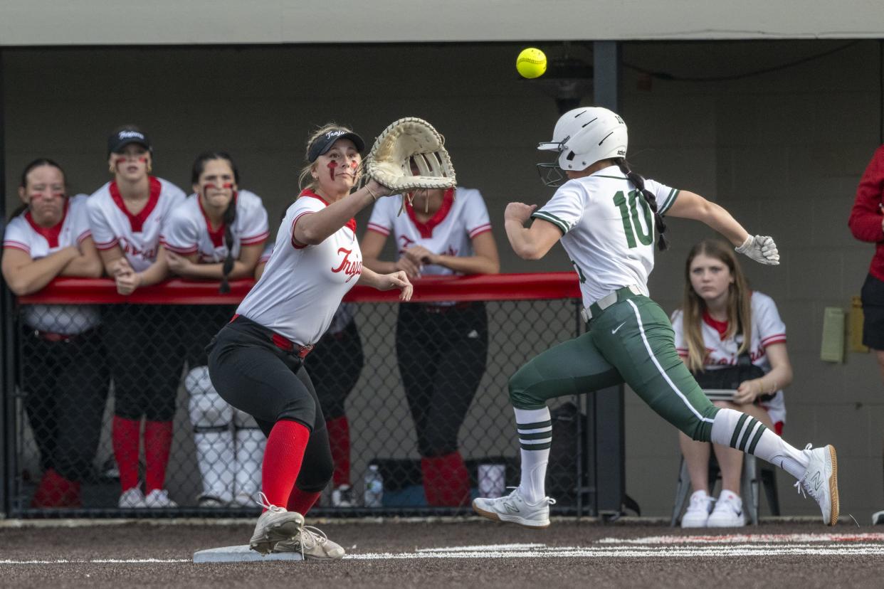 Center Grove High School junior Sydney Herrmann (16) makes the catch at first base to get an out on Pendleton Heights High School senior Kiah Hubble (10) during an IHSAA softball game, Friday, March 29, 2024. Host Center Grove won, 7-6.