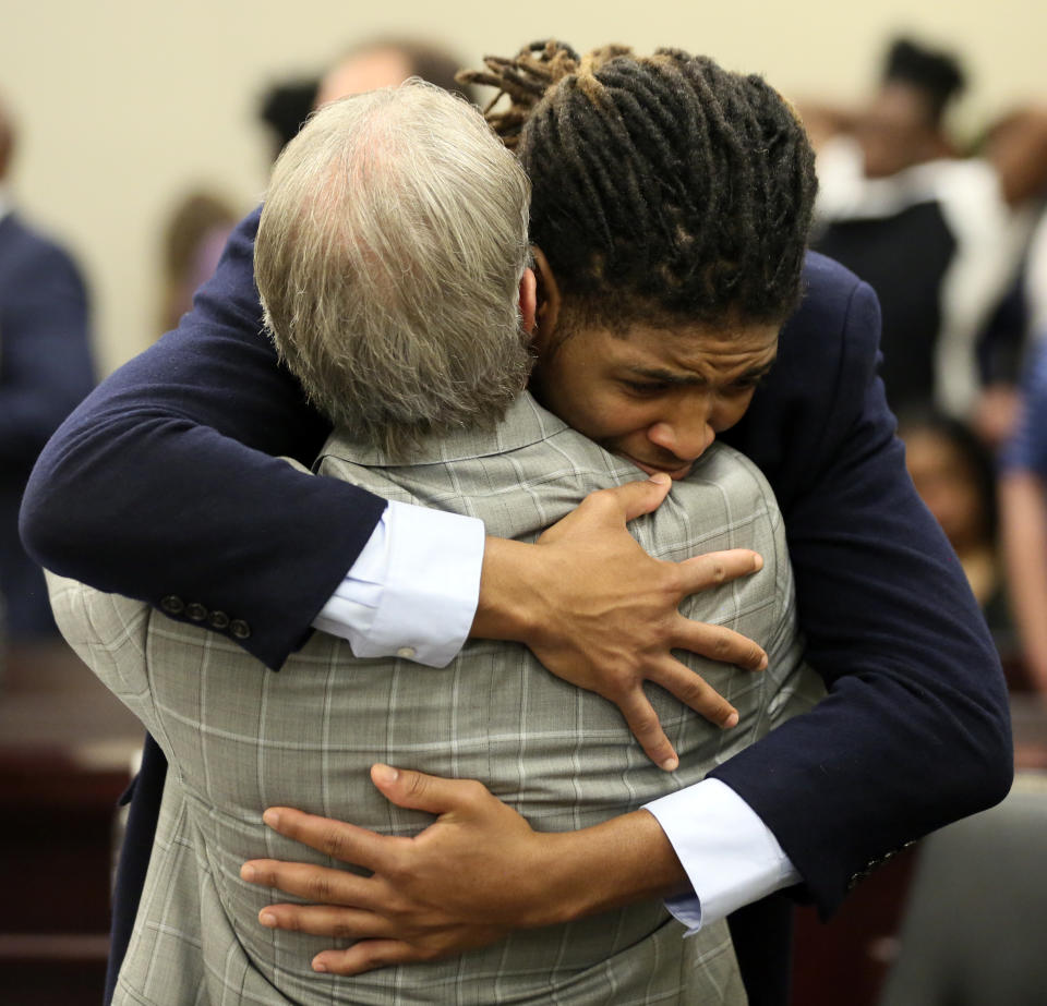 Former Virginia Tech football player Isimemen David Etute hugs his defense attorney Jimmy Turk after closing arguments in his trial in Montgomery County Circuit Court in Christiansburg, Va., Friday May 27 2022. Etute is accused of fatally beating Jerry Smith, 40 in May 2021, a man he met on an online dating site and had initially believed to be a woman. (Matt Gentry/The Roanoke Times via AP)