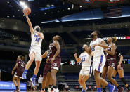 In this photo provided by DePaul Athletics, DePaul's Lexi Held (10) goes to the basket against Texas A&M as teammates Dee Bekelja (23) and Darrione Rogers (21) look on during an NCAA college basketball game on Saturday, Nov. 28, 2020, in Chicago. It's a common sight to see players and coaches wear masks on the sideline so far this season during college basketball games to help prevent the spread of the coronavirus. The DePaul and Creighton women's basketball teams are among a few squads that have taken it a step further with their players wearing the masks while they are on the court playing. (Steve Woltman/DePaul Athletics via AP)