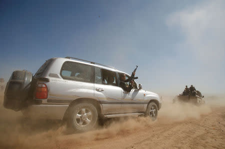 A tribesman holds a rifle as he emerges from the window of a car during a tribal gathering held to show support to the new government formed by Yemen's armed Houthi movement and its political allies, in Sanaa, Yemen December 6, 2016. REUTERS/Khaled Abdullah