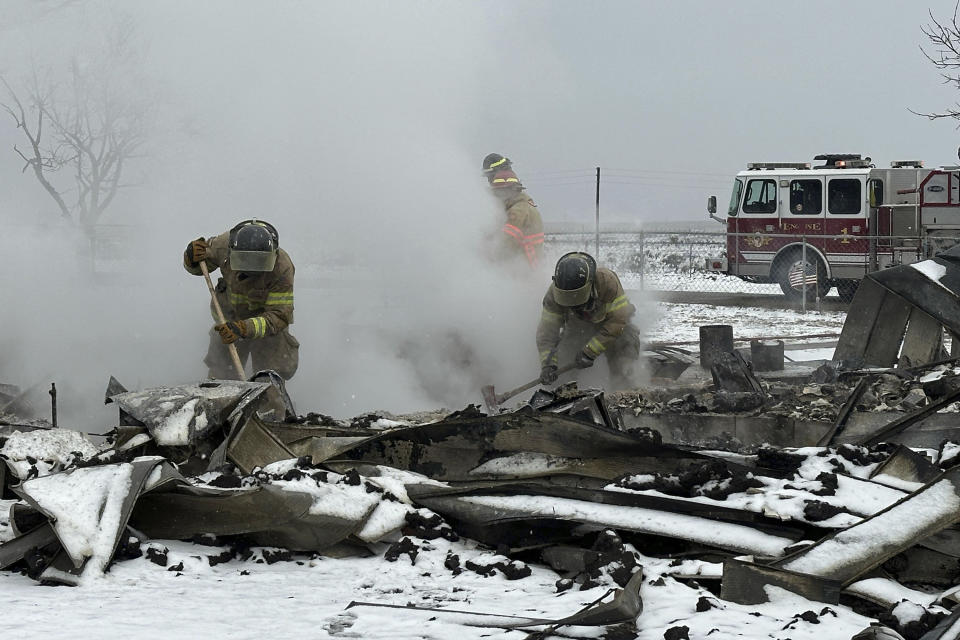 Firefighters work through rubble of burned homes from the Smokehouse Creek fire in Stinnett, Texas on Thursday, Feb. 29, 2024. A wildfire spreading across the Texas Panhandle became the largest in state history Thursday, as a dusting of snow covered scorched prairie, dead cattle and burned out homes and gave firefighters a brief window of relief in desperate efforts to corral the blaze. (AP Photo/Ty O'Neil)