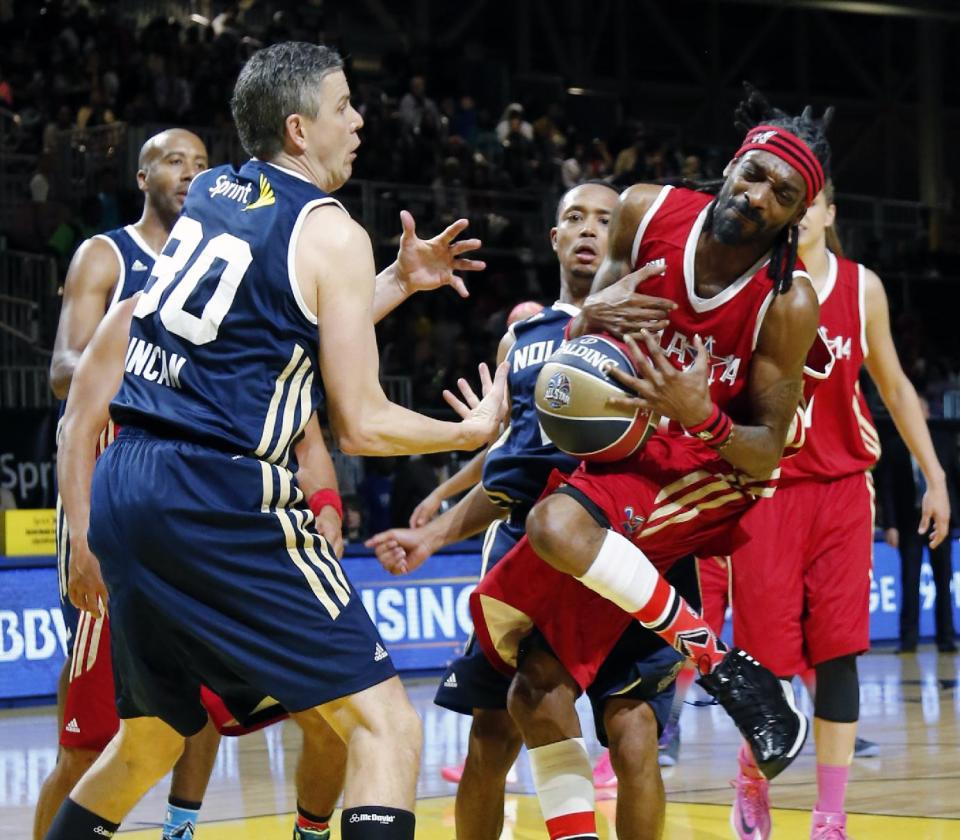 U.S. Education Secretary Arne Duncan, left of the East team struggles with West's Snoop Dogg for a loose ball in the second half of the NBA All-Star Celebrity basketball game in New Orleans, Friday, Feb. 14, 2014. The East won 60-56. (AP Photo/Bill Haber)