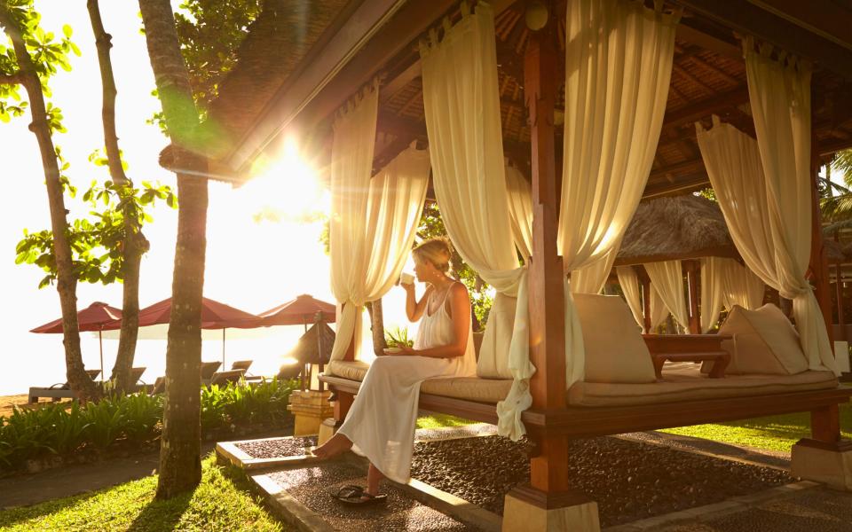 Woman relaxing in hut on tropical beach