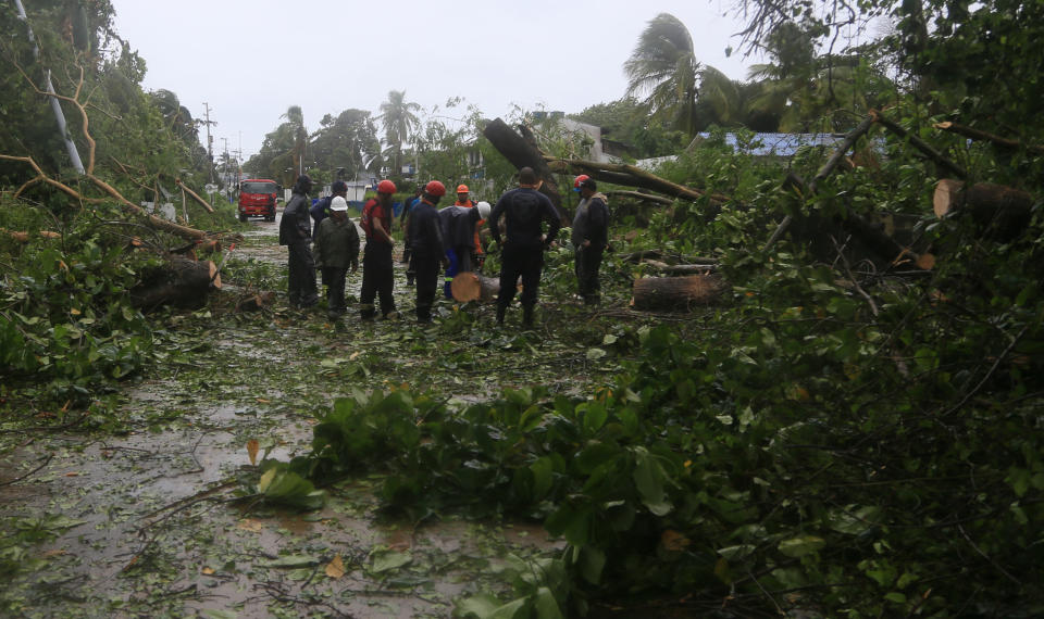 Workers cut up trees felled by Hurricane Iota on San Andres island, Colombia, Monday, Nov. 16, 2020. Iota moved over the Colombian archipelago of San Andres, Providencia and Santa Catalina, off Nicaragua’s coast, as a Category 5 hurricane. (AP Photo/Christian Quimbay)