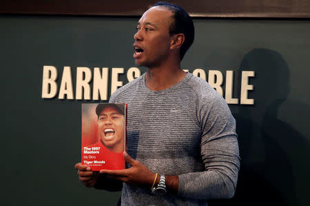 Golfer Tiger Woods poses with a copy of his new book "The 1997 Masters: My Story" at a book signing event at a Barnes & Noble store in New York City, New York, U.S., March 20, 2017. REUTERS/Mike Segar