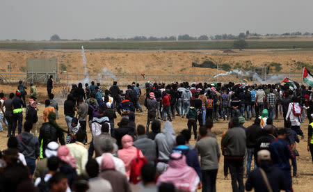 Palestinian demonstrators gather during clashes with Israeli troops at a protest demanding the right to return to their homeland, at the Israel-Gaza border in the southern Gaza Strip, April 27, 2018. REUTERS/Ibraheem Abu Mustafa