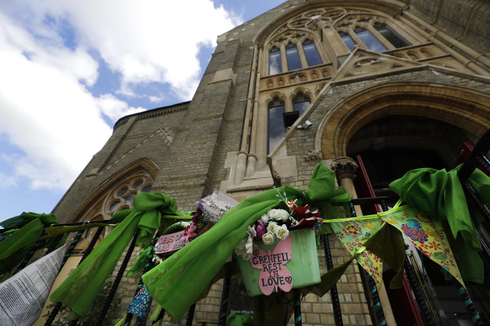 Tributes are tied to the railings outside Notting Hill Methodist Church near Grenfell Tower in London, Sunday, June 14, 2020. Britain is marking the third anniversary of the Grenfell Tower fire with a virtual church service to remember the 72 people who died in the blaze. Sunday marks three years since a small kitchen fire in the west London public-housing block turned into the worst domestic blaze in the country since World War II. (AP Photo/Kirsty Wigglesworth)