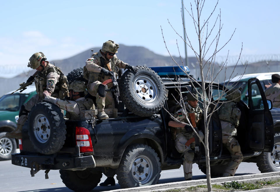 Afghan special forces soldiers arrive at the site of a gun battle between security forces and insurgents in an Independent Elections Commission (IEC) office in Kabul, Afghanistan, Tuesday, March 25, 2014. Gunmen stormed into the building, trapping dozens of employees inside and killing many people. A candidate for a seat on a provincial council was among those killed, along with an election worker, a civilian and a policeman. (AP Photo/Massoud Hossaini)