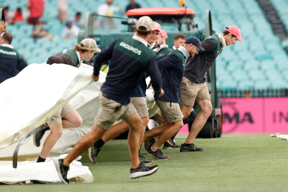 SYDNEY, AUSTRALIA - JANUARY 04: Ground staff pull the covers out as rain begins to fall during day two of the Men's Third Test Match in the series between Australia and Pakistan at Sydney Cricket Ground on January 04, 2024 in Sydney, Australia. (Photo by Darrian Traynor/Getty Images)