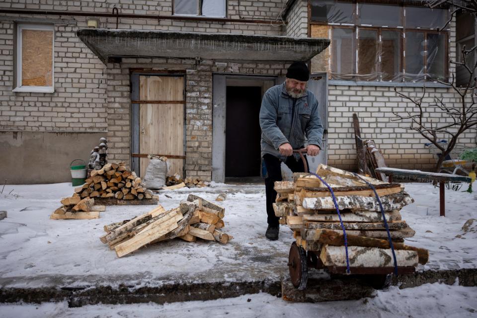 Hennadiy Batsak, 63, gathers wood he uses to heat his apartment that lacks heating, water and gas in the frontline town of Lyman (REUTERS)