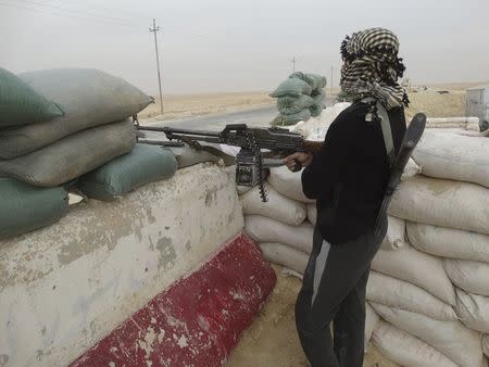 A tribal fighter takes up a position during an intensive security deployment against Islamic State militants in Haditha November 14, 2014. REUTERS/ Stringer